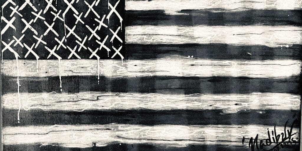 A black and white american flag painted on the side of a building.