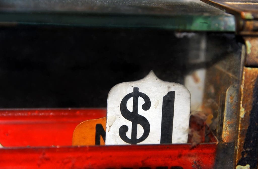 Close-up of a weathered price tag showing "$1" in an old cash register.