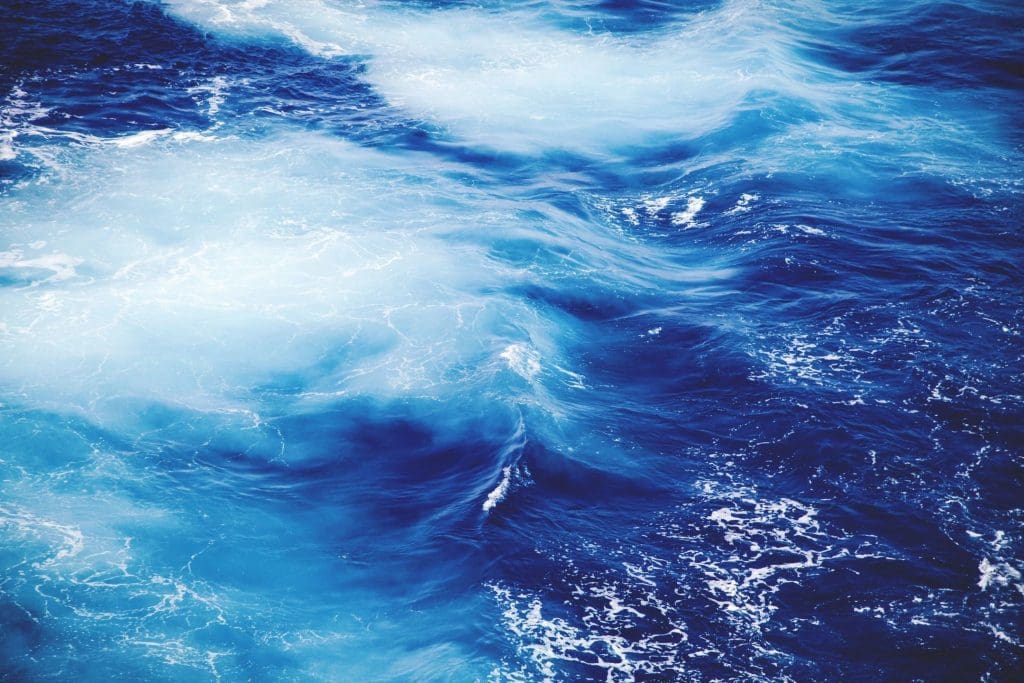 Vivid blue ocean waves with white foam.